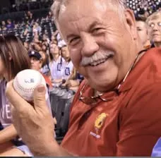 Ferris State supporter holding a baseball in stadium seating